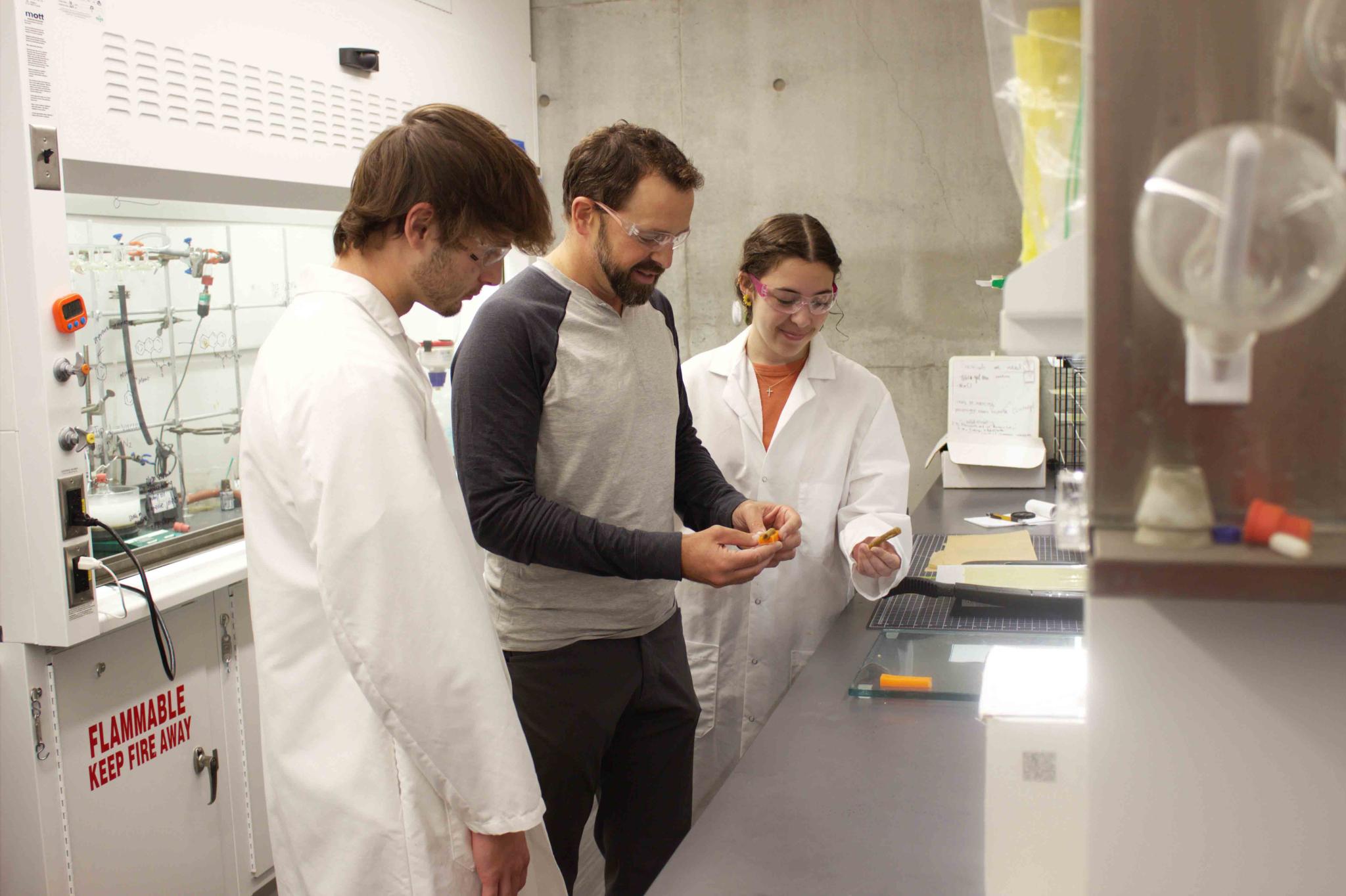 A professor and two students work on innovative glue in the lab.