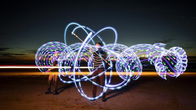 SLO GLO, a student glow-in-the-dark flow arts club, practices their art on the beach.