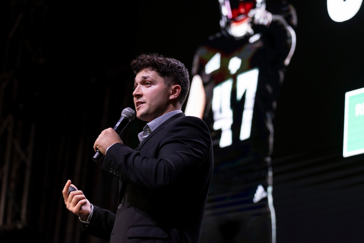 ODIN CEO Connor Heffler presents with a picture of a football player behind him.