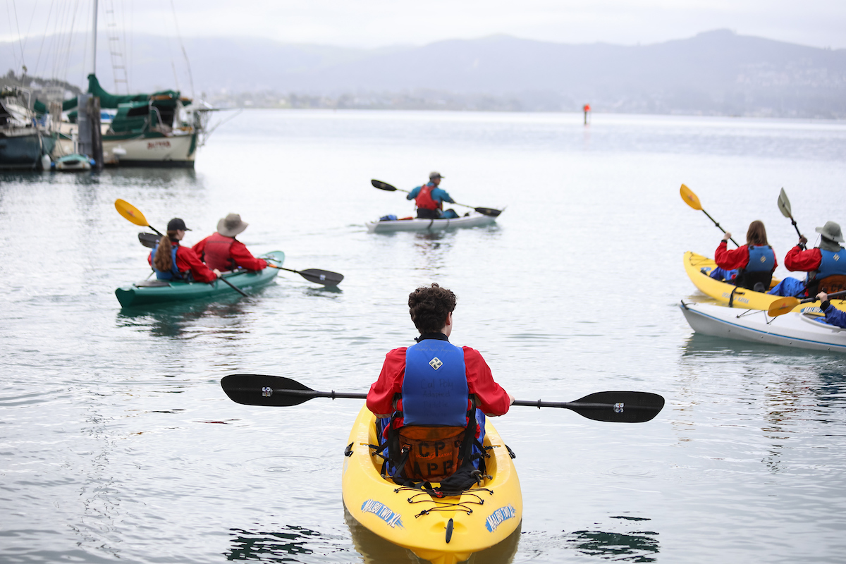 Student Luke Hansen paddles a yellow kayak in Morro Bay.