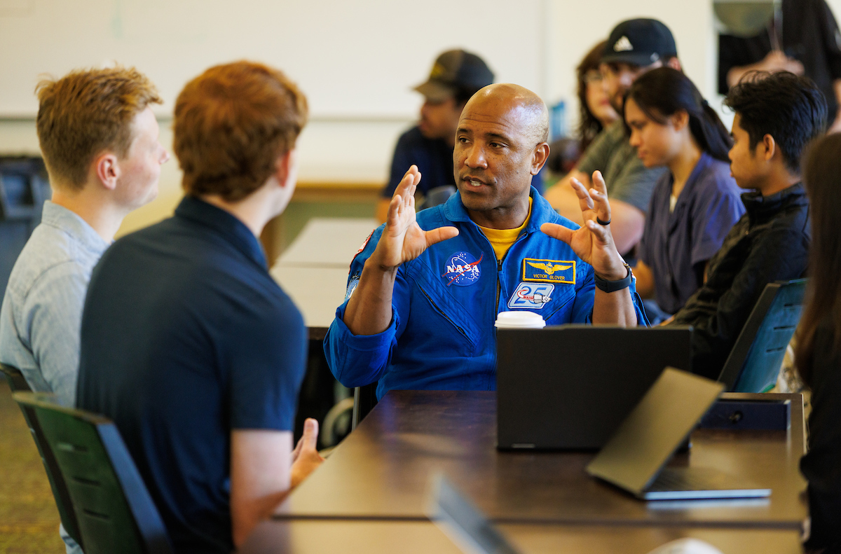 Victor Glover speaks with engineering students developing exercise solutions for astronauts.
