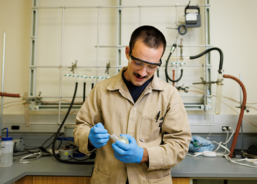 Chemistry student Sal Deguara wears protective gear as he works with a compound in professor Scott Eagons lab