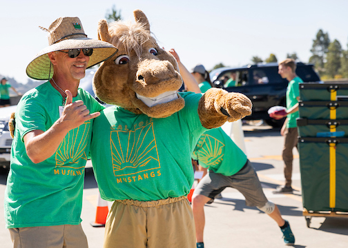 Musty, the school mascot, and a volunteer assist during move-in week