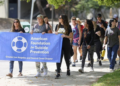 Walkers holding an American Foundation for Suicide Prevention lead a group during a past Out of the Darkness Walk