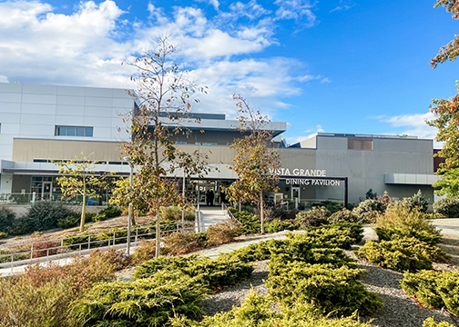 A view of the outside of Vista Grande dining complex with a blue sky with clouds