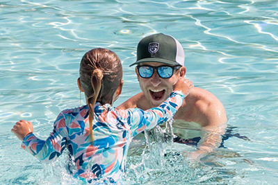 an instructor and child in the pool having a swim lesson