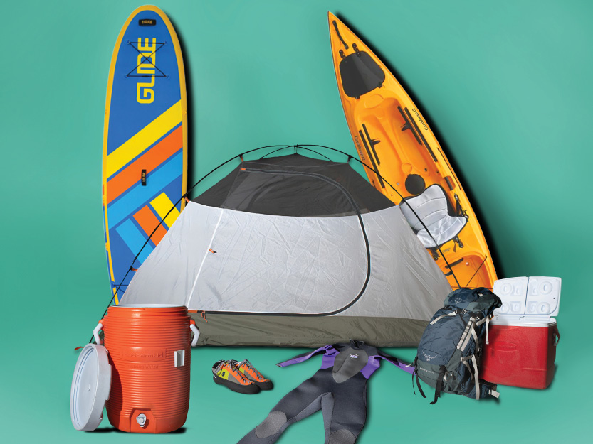 A photo illustration showing vacation equipment including a tent, kayak, paddleboard, wetsuit, backpack and other equipment