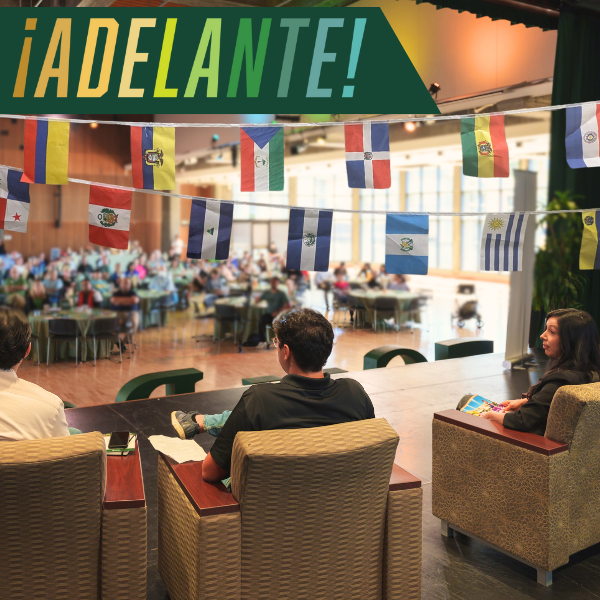 ALT TEXT:  Cal Poly student and staff panelists pictured on stage in Chumash Auditorium during the 2023 HSI Symposium with colorful Latine Country flags hanging above them. Text overlay reads ¡Adelante!