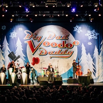 Band plays on stage with a winter backdrop.