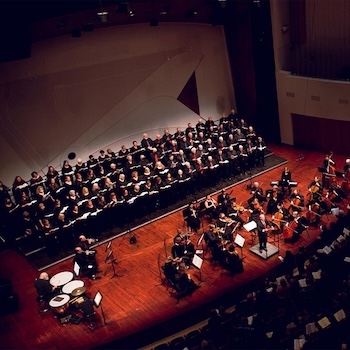 Choir and symphony play on stage.