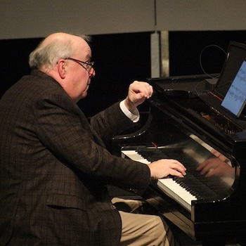 Professor Emeritus W. Terrence Spiller plays the piano.