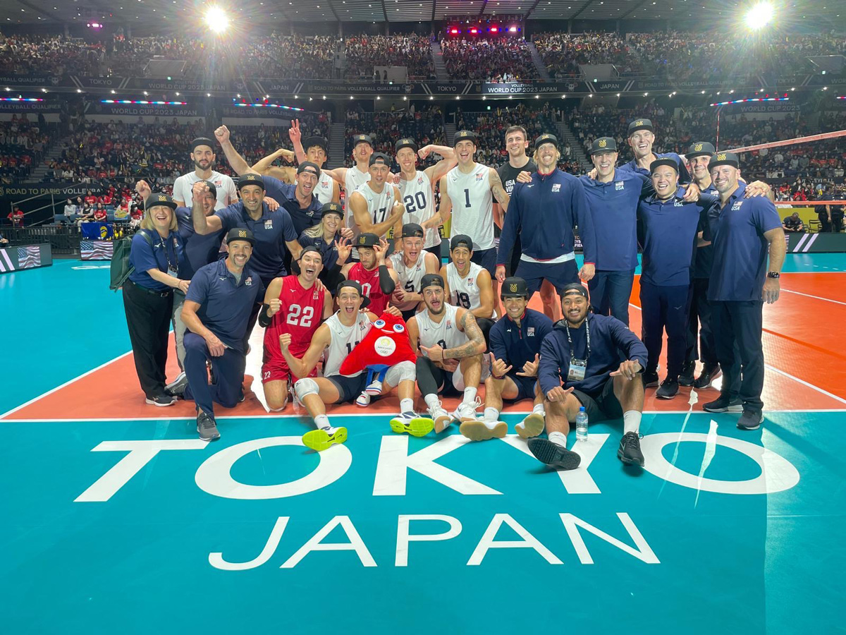 The U.S. Men's National indoor volleyball team takes a photo in a stadium in Tokyo.