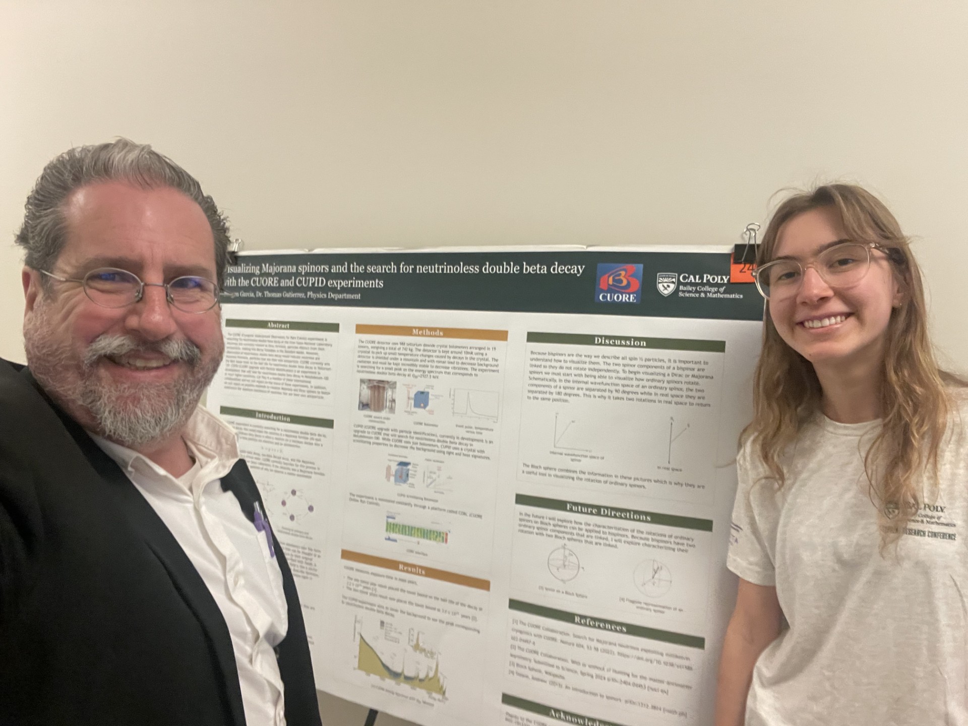 Physics professor Tom Gutierrez and student Reagen Garcia stand with a posterboard of their research. 