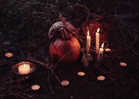 Pumpkins and candles arranged on a dark background