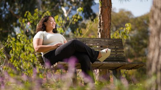 Kiana Corey sits under an arbor on the Cal Poly campus