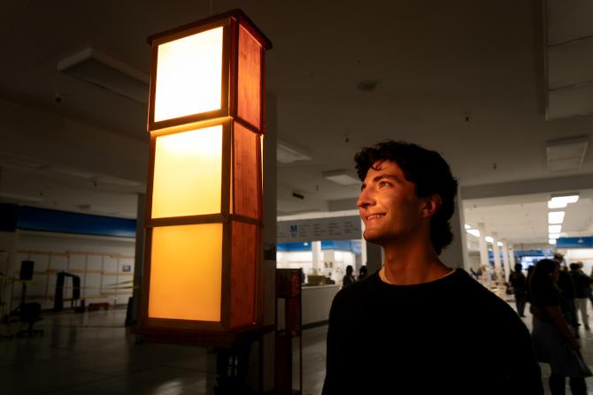 A student interacts with a student-built piece at the Vellum Furniture Competition.