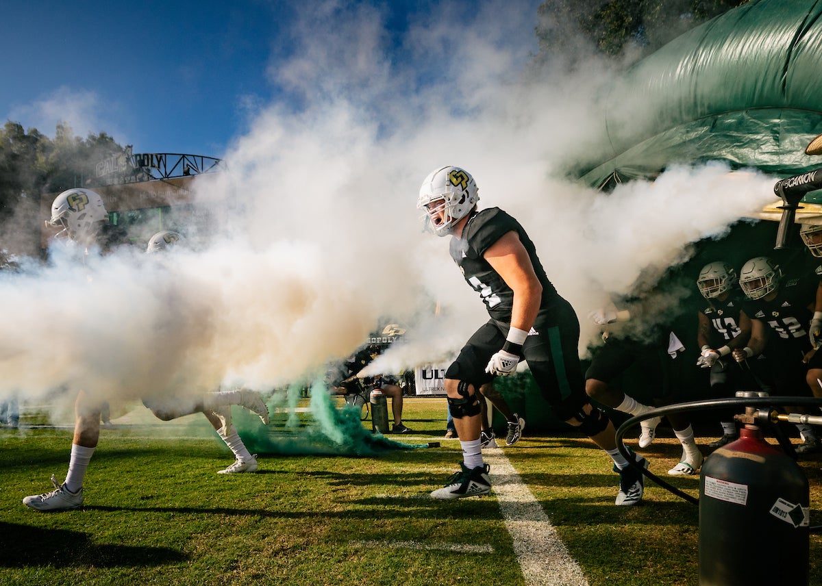 Football players rush out of the tunnel and onto the field at Alex G. Spanos Stadium.