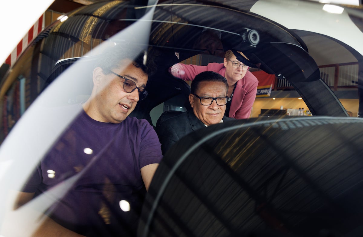 Professor Paulo Iscold chats with congressman Salud Carbajal in the cockpit of a small plane, with engineering dean Amy Fleischer behind them.