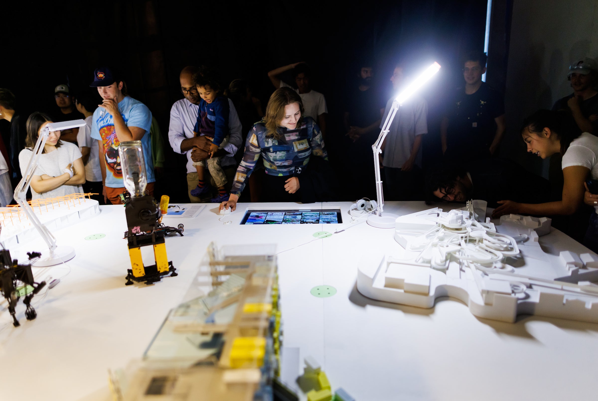 Students gather in a darkened room to see an exhibit put on by 5th-year architecture students.