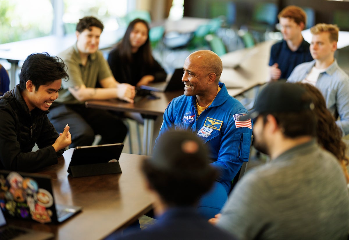 Astronaut Victor Glover, center, with students on campus in May.