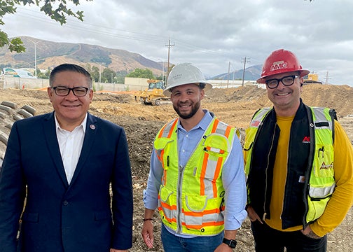 Congressman Salud Carbajal with two Cal Poly workers in hard hats and tech park building project site