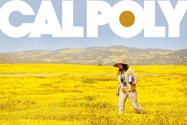 Student walks across a field of yellow flowers