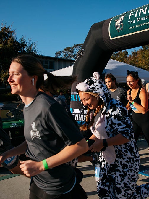 Students, some in costume, start the Mustang Mile at a previous 5K event