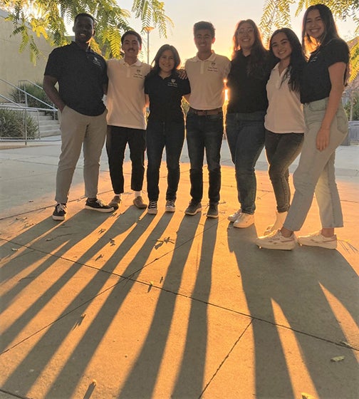 A group of students with back to the sun casts long shadows