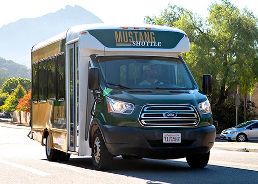 A Mustang Shuttle drive on campus perimeter road with Bishop Peak in the background