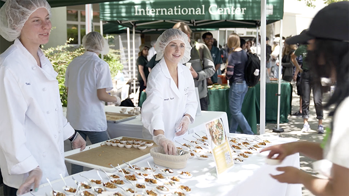 Students in the FSN lab serving samples for the 2022 Taste of the World.