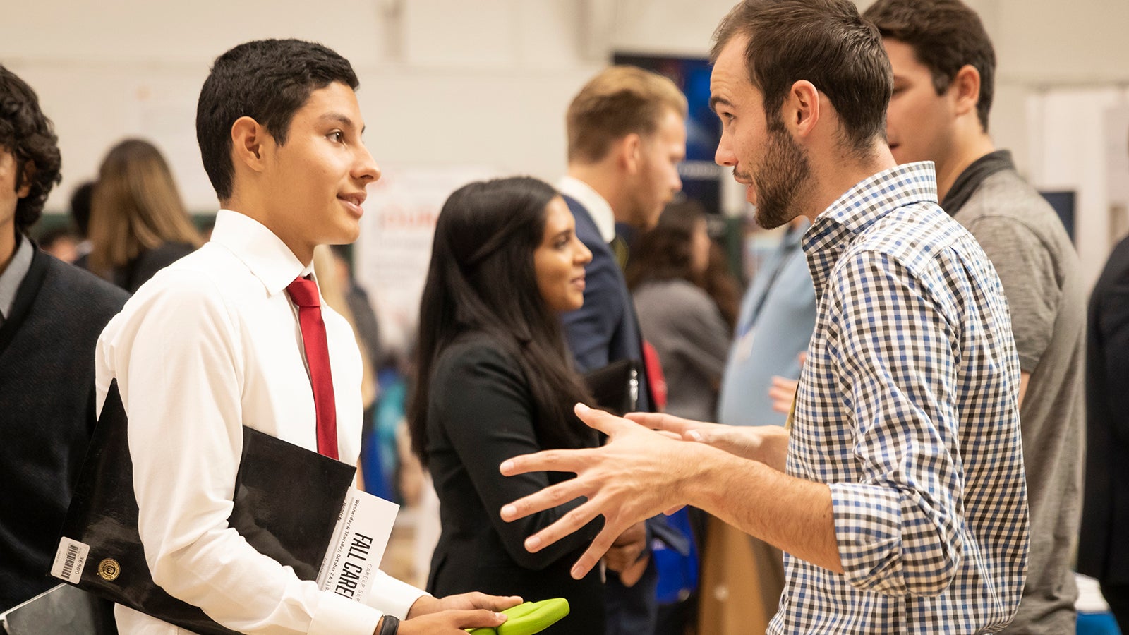 Student speaks with a recruiter at a career fair.