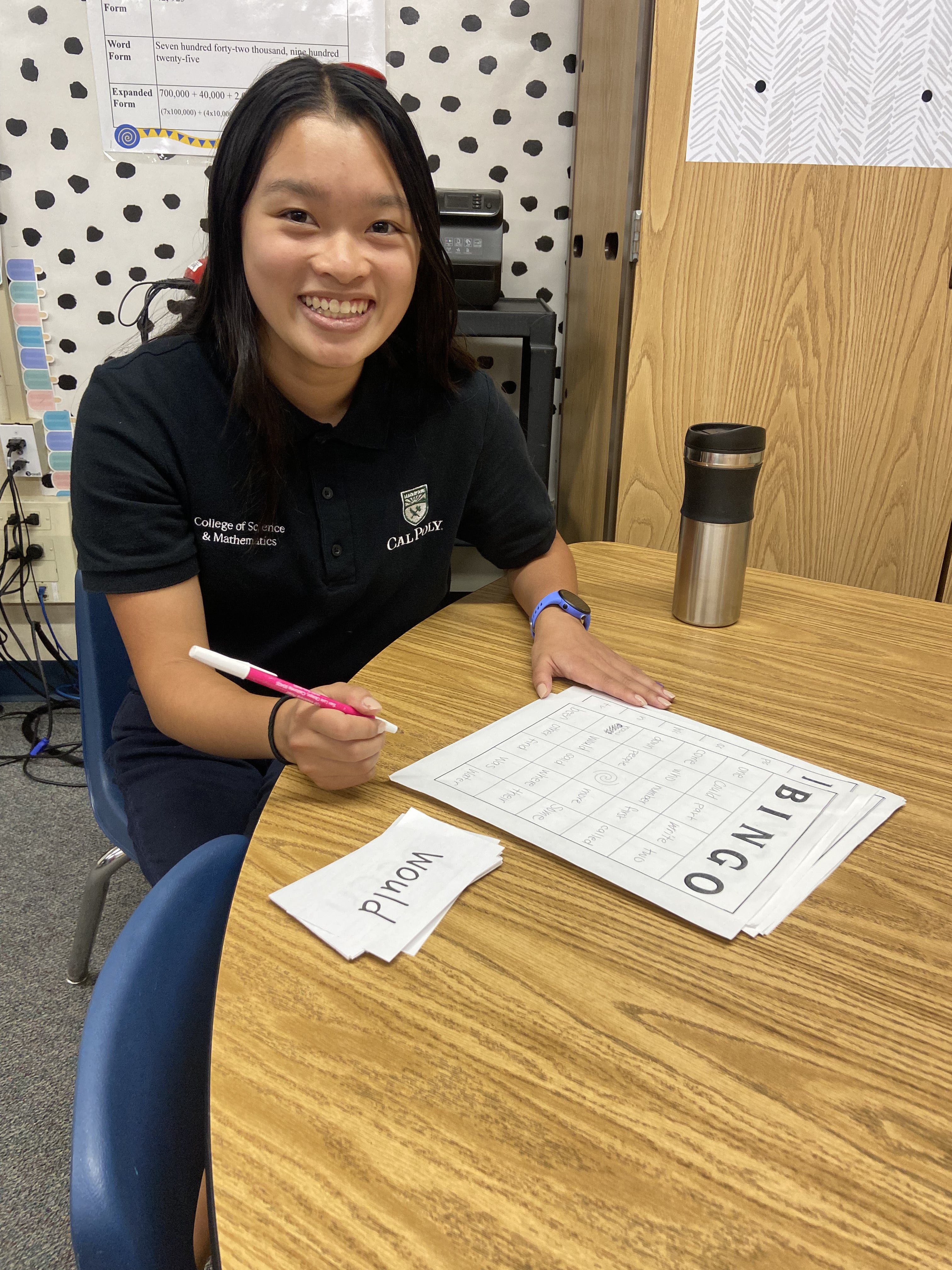 Student Kaylie Kwan sits at a desk with educational papers around her. 