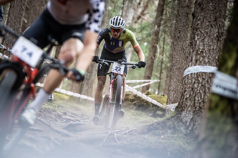 Christopher Blevins, wearing a bike racing outfit, grips the handlebars of his mountain bike during a race. 