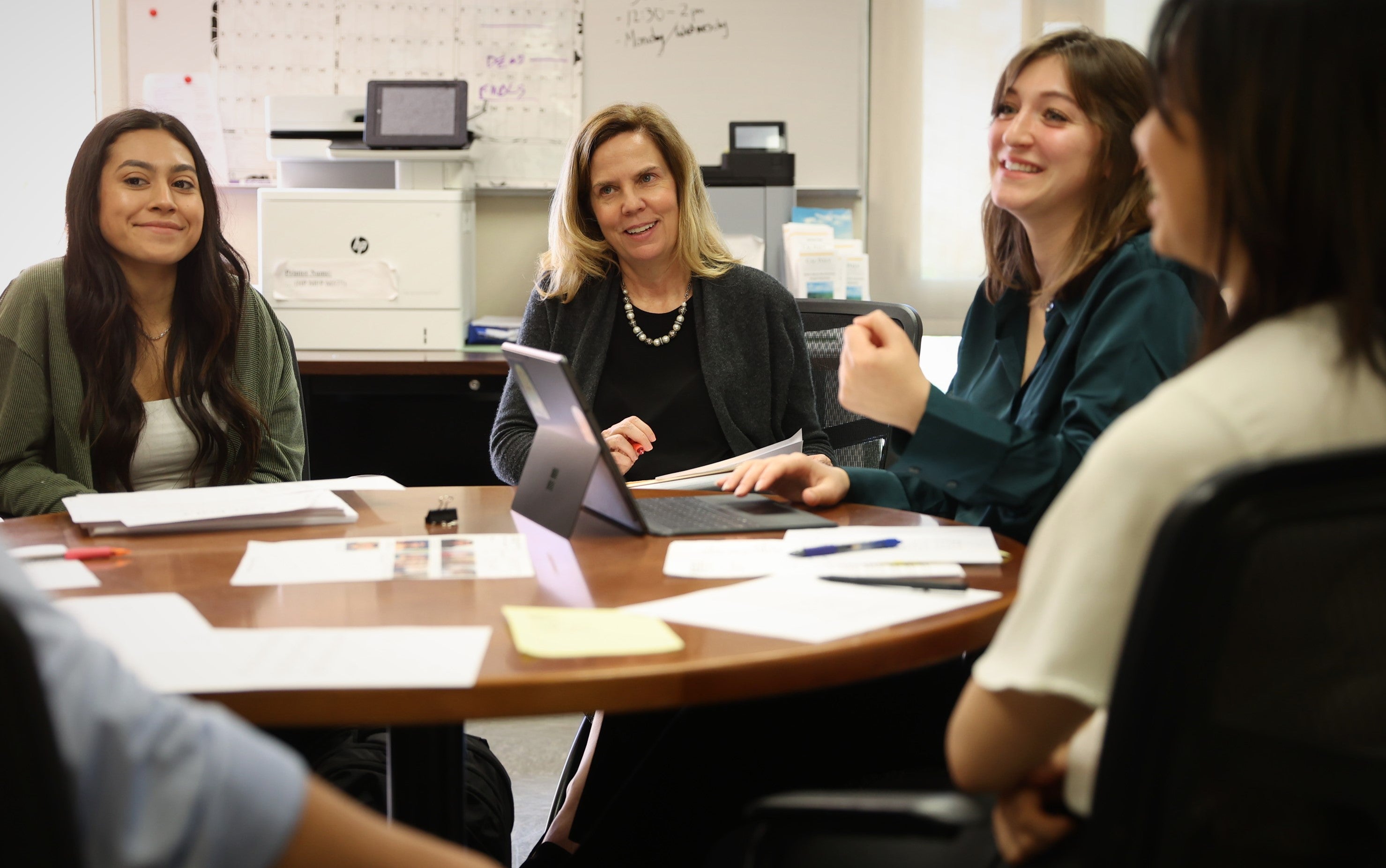 Low Income Taxpayer Clinic Director Lisa Sperow, center, meets with students on the clinic's leadership team at a table.