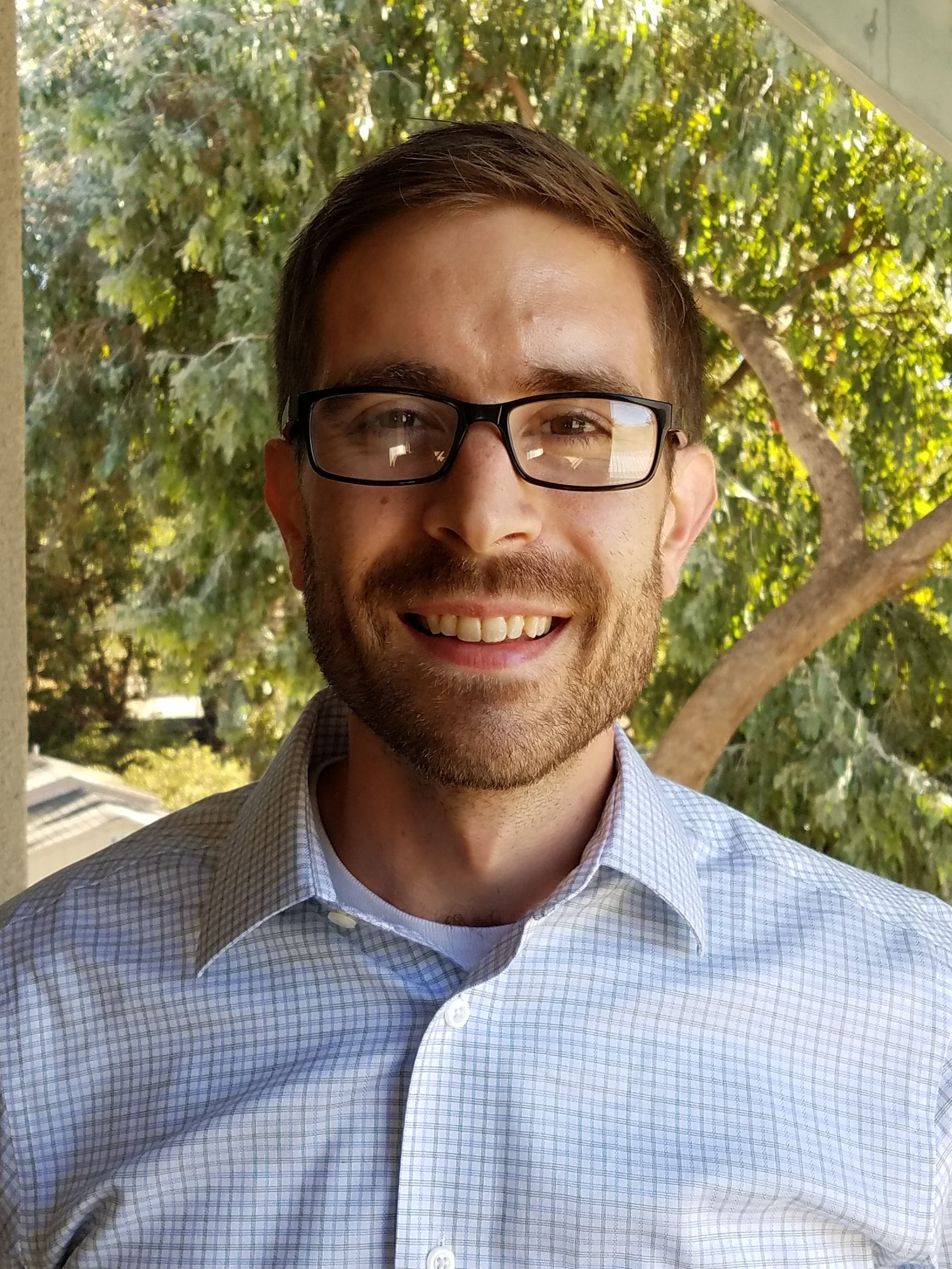 A headshot of professor Benjamin Lutz wearing a light blue button down.