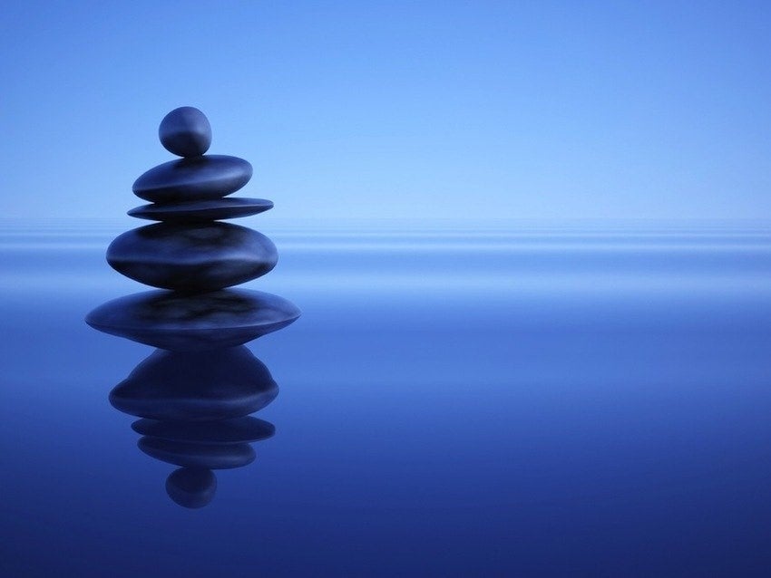 Stones stacked on top of each other, balancing on water.