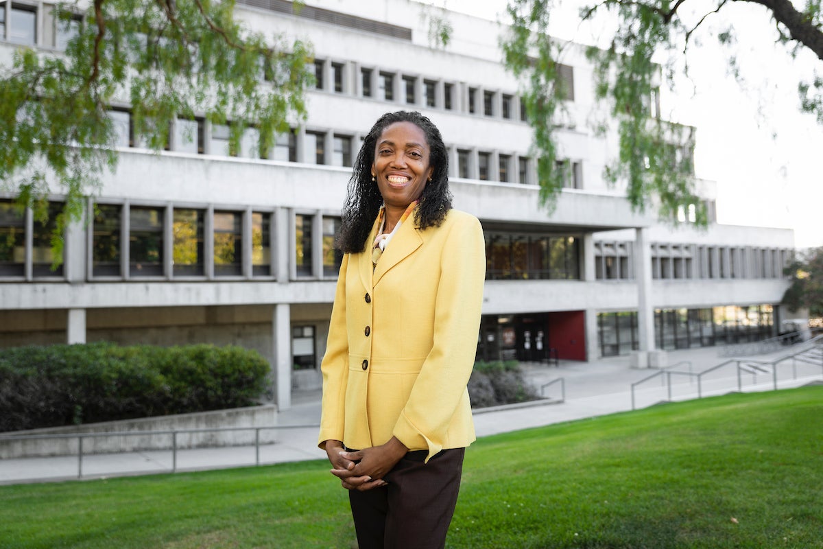 Jackson-Elmoore stands in front of the Kennedy Library wearing a yellow jacket