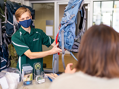 A student helps a customer at the Poly Escapes Rental Center.