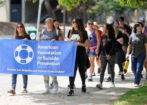 Walkers holding an American Foundation for Suicide Prevention lead a group during a past Out of the Darkness Walk