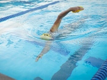 Swimmer in pool swims laps. 