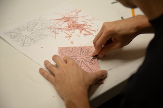 Person carves rubber mat for a block printing workshop.