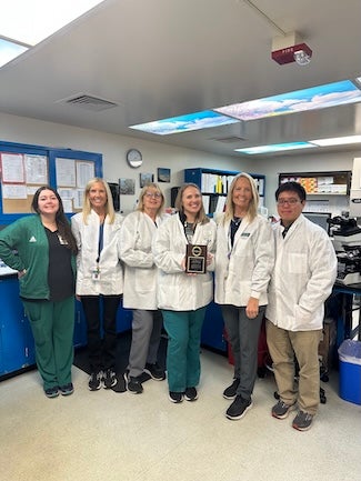 Nursing staff pose together in a laboratory.