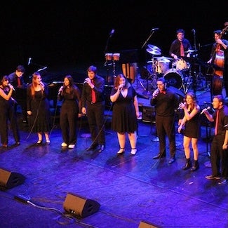 Singers and musicians perform on stage.