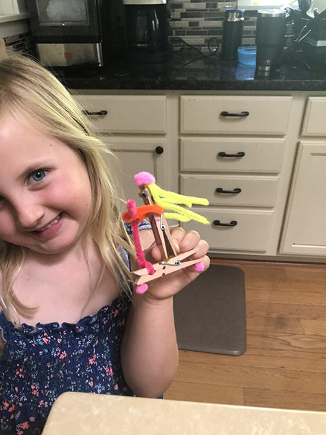 Preschool student Evelyn poses with a craft she made as part of the Preschool Learning Lab. 