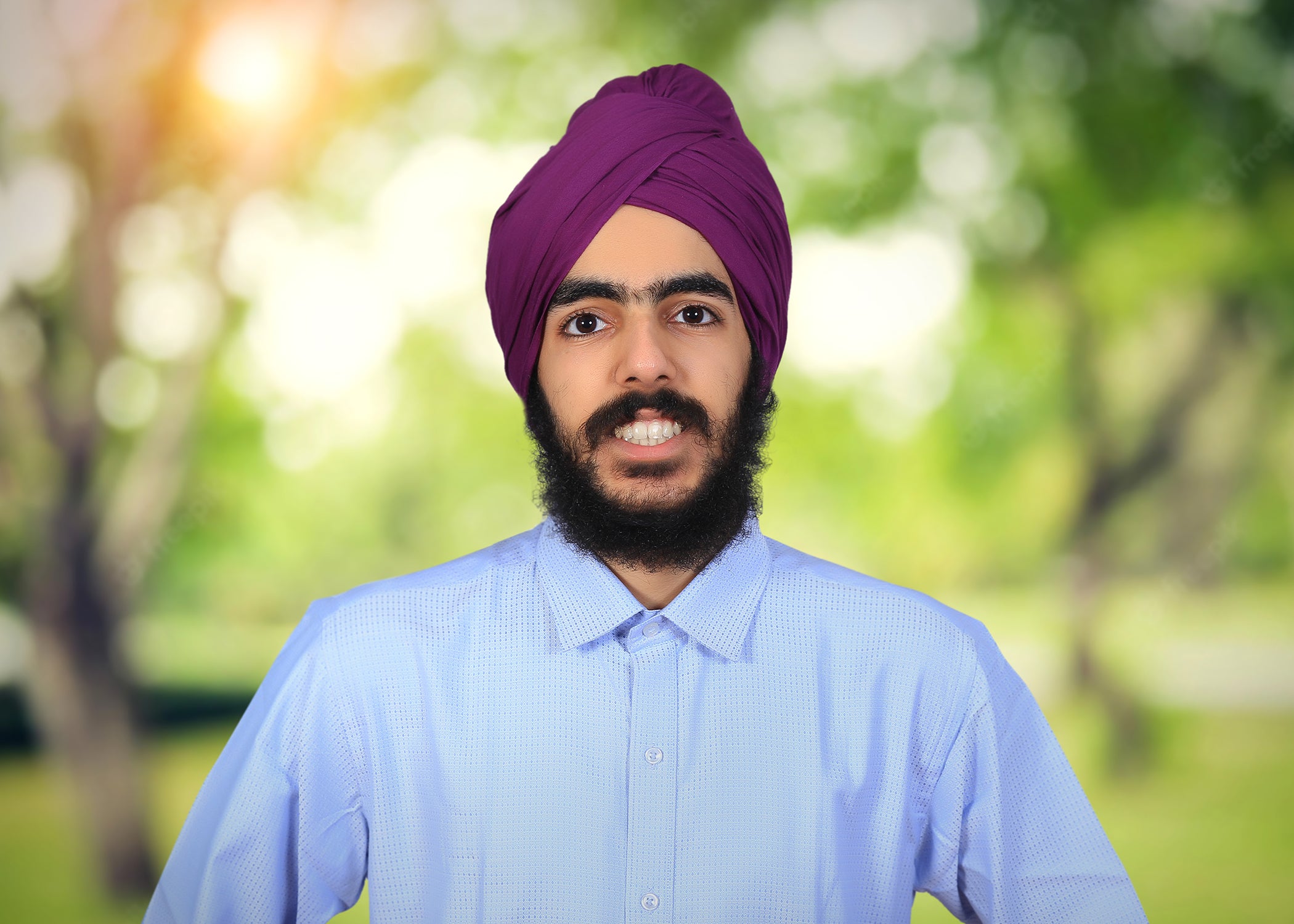 A portrait of a young man in a beard, turban and collared shirt