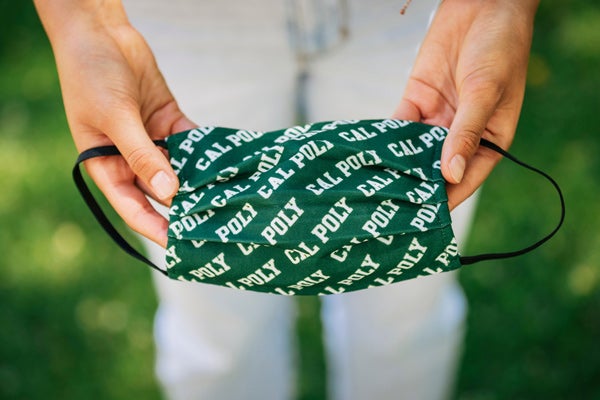 Hands holding a Cal Poly branded mask.