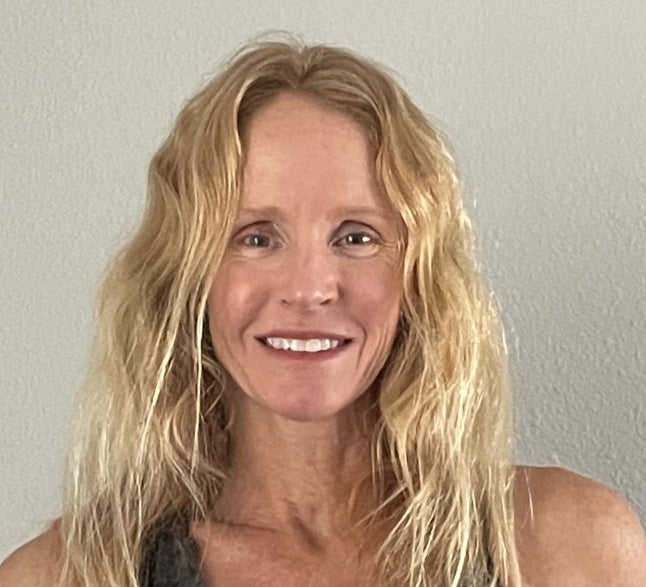 A headshot of kinesiology professor Nicole Hagobian, who has blond hair, against a white wall.