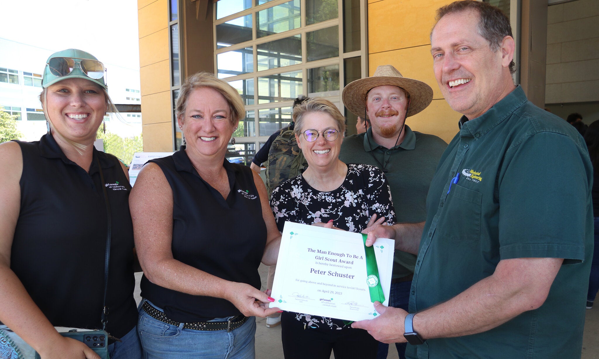 Professor Peter Schuster, right, receives his Man Enough to be a Girl Scout Award from Girl Scouts of  Central Coast representatives