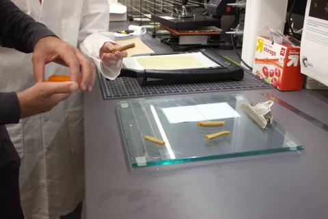 Pieces of a new kind of debondable glue stick on a glass clipboard in a lab.