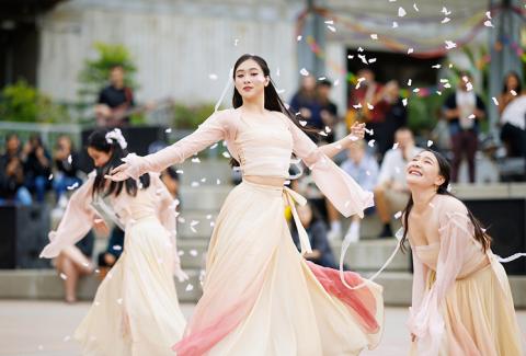 A young woman dancing at the University Union Plaza as confetti rains down